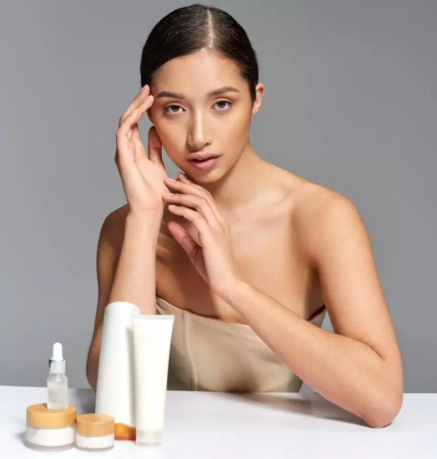 beauty industry, skin care, young asian woman with brunette hair posing near beauty products
