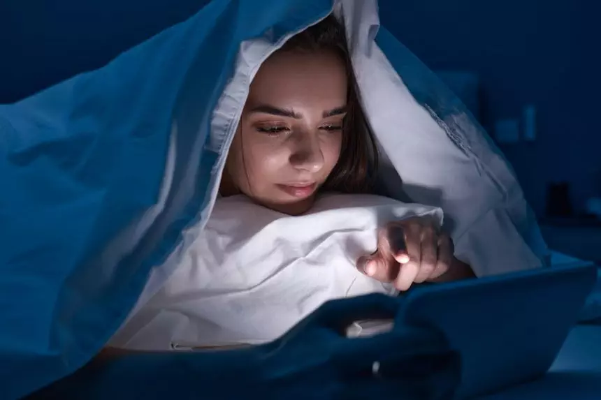 Woman using gadget in bed